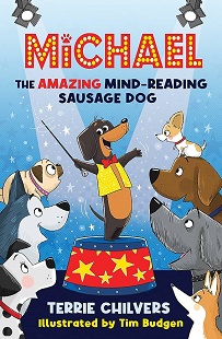 Book cover for MICHAEL THE AMAZING MIND-READING SAUSAGE DOG: title above graphic of a dog in a waistcoat on a circus podium surrounded by other dogs